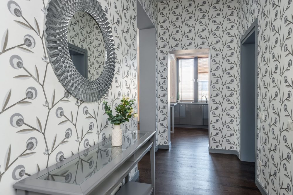 Botanical-print hallway with a round mirror and a slim console table