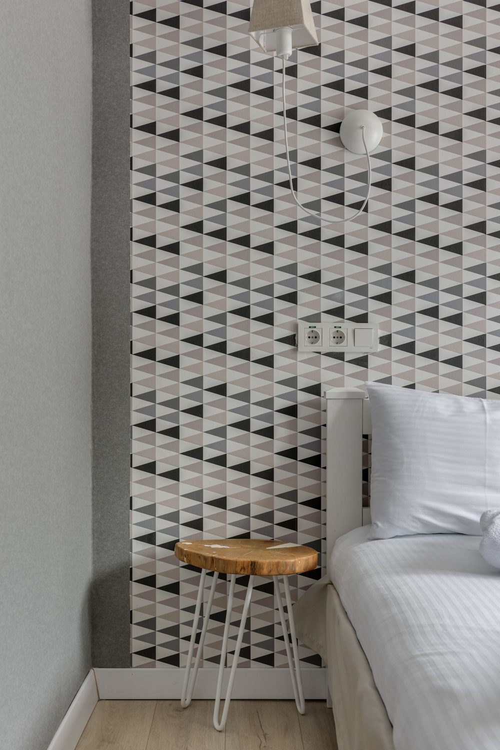 Modern bedroom corner in a grey geometric triangle print