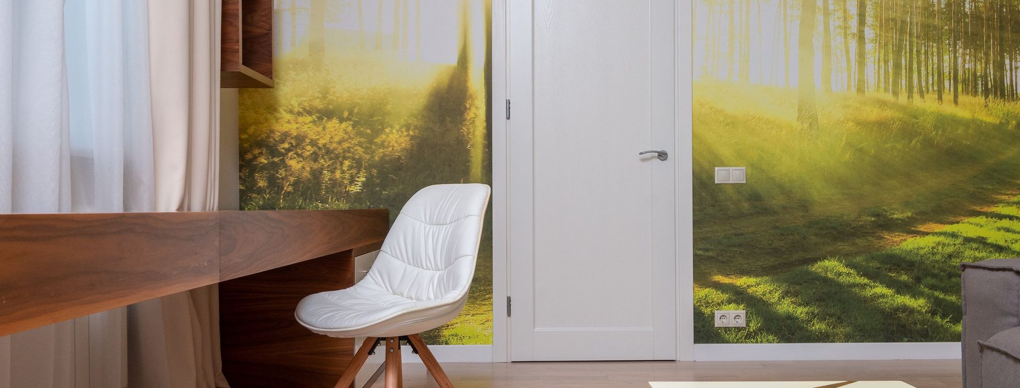A bright residential room finished with a full-wall forest mural wallpaper